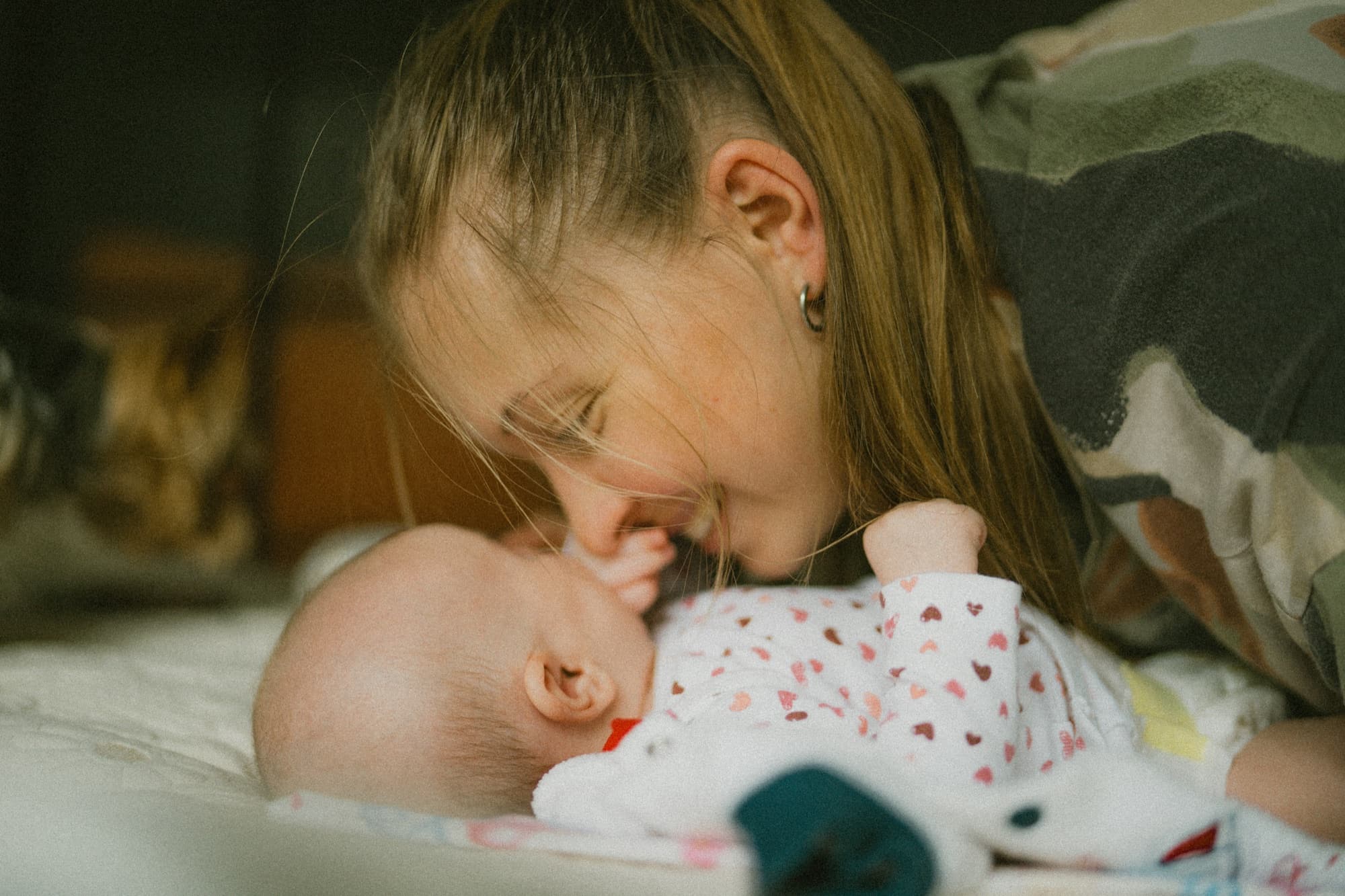 Mama czule pochylająca się nad małym dzieckiem